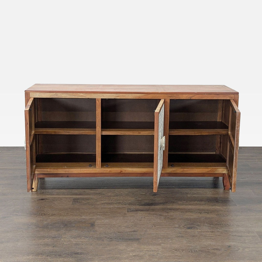 Wooden sideboard by Signature Design by Ashley showcasing intricate carving on three doors and inner shelving.