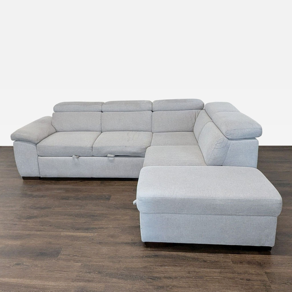 Light gray sleeper sofa with chaise lounge, pull-out bed, and hidden storage, ideal for modern living rooms.