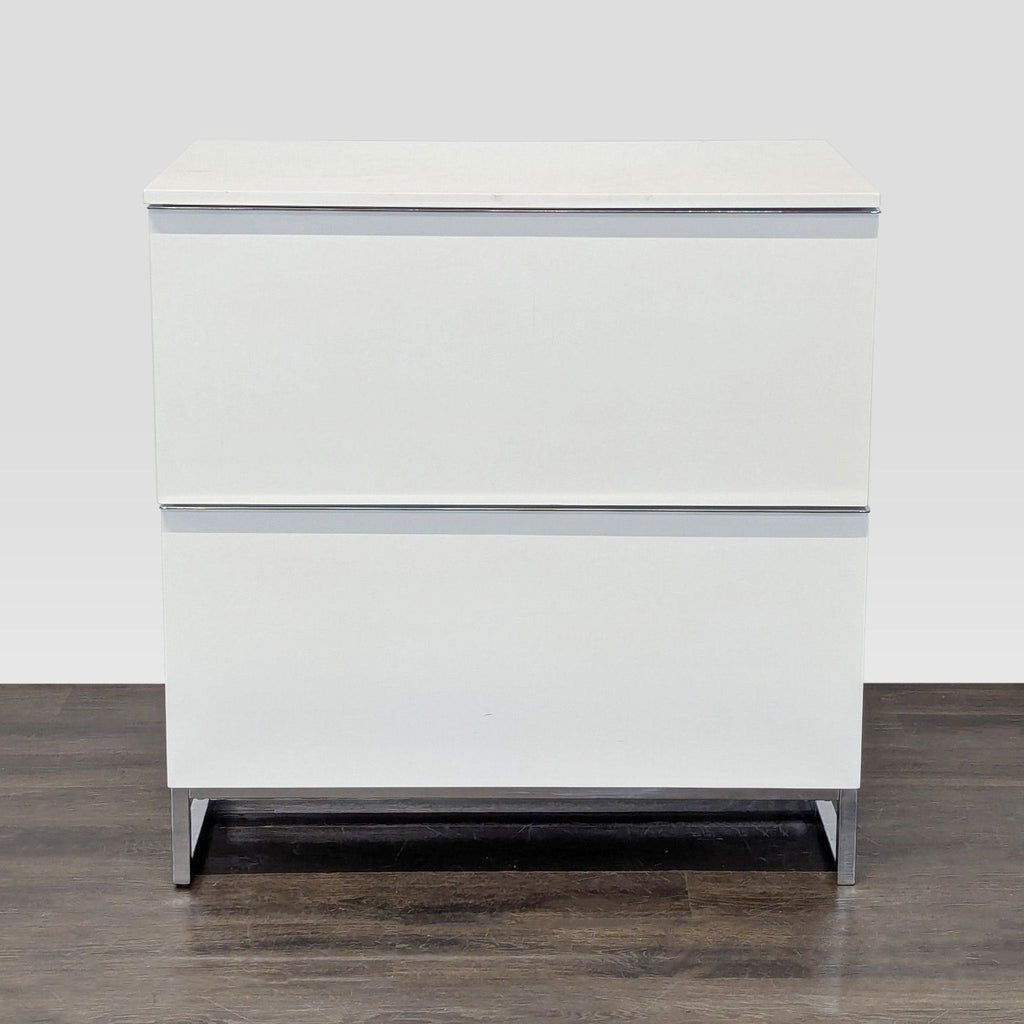 White cabinet with two drawers, metal legs, and a modern Scandinavian Design style, perfect for storage.  