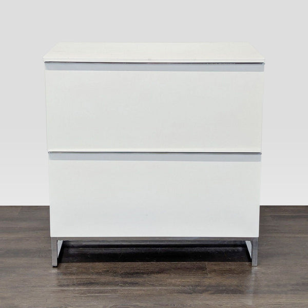 White cabinet with two drawers, metal legs, and a modern Scandinavian Design style, perfect for storage.  