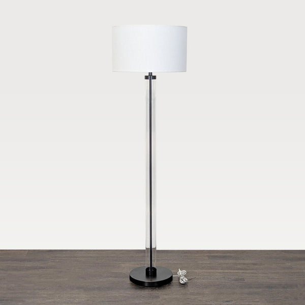 1. Arhaus floor lamp with clear glass cylinder base, black foundation, and white drum shade, shown with cord.