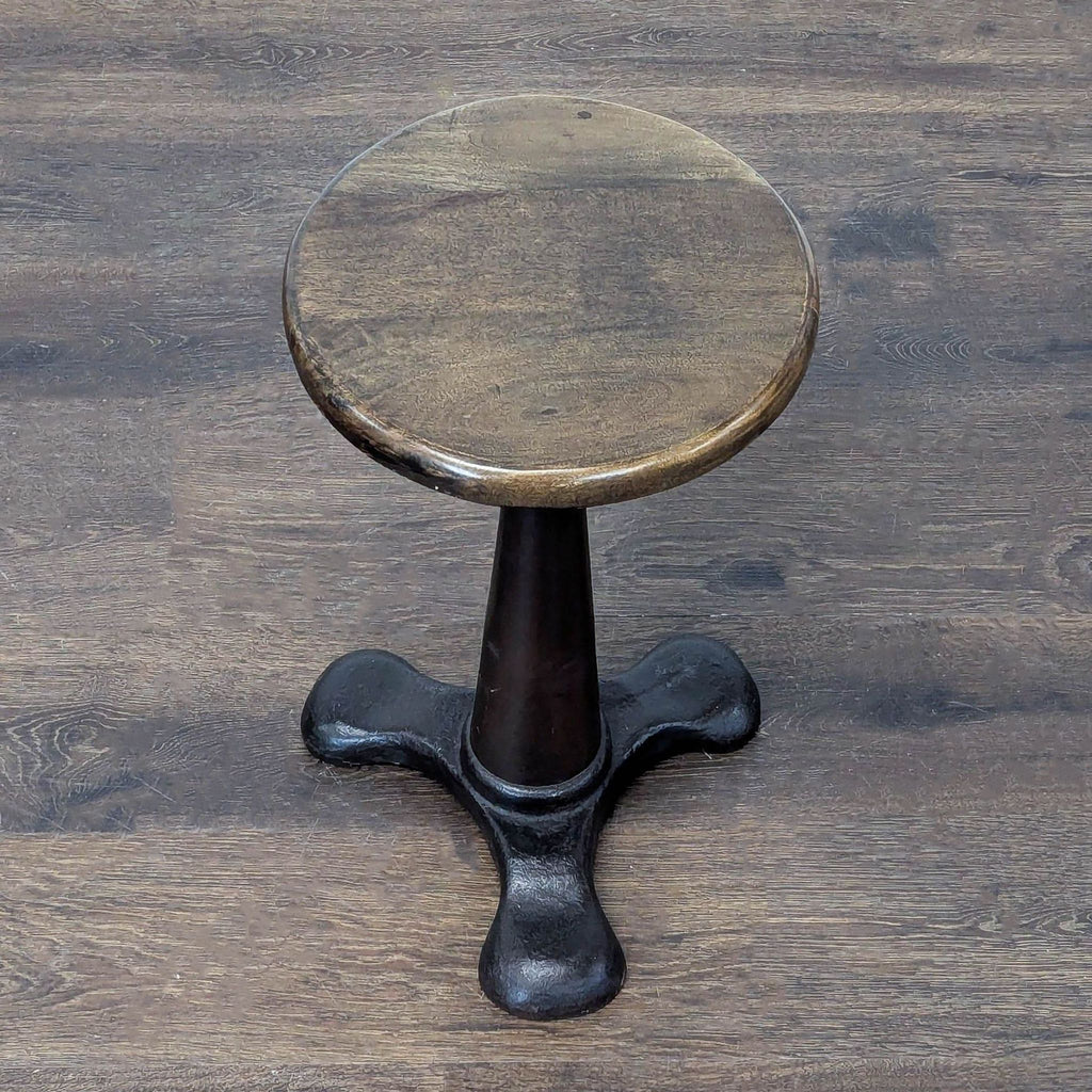 Adjustable-height stool with a central twist mechanism and circular seat.  