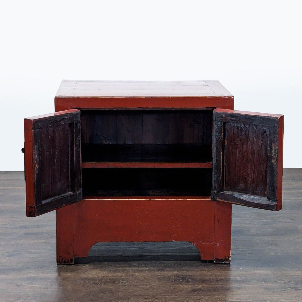 Glossy red end table featuring metal handles and a single interior shelf.  