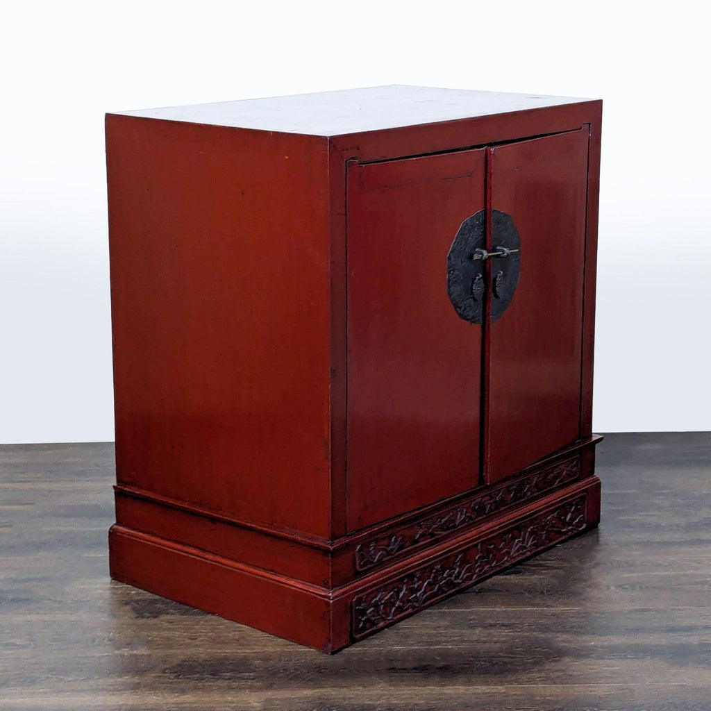 Antique cabinet in red lacquer, highlighted by a carved base and an ornate engraved lock plate.