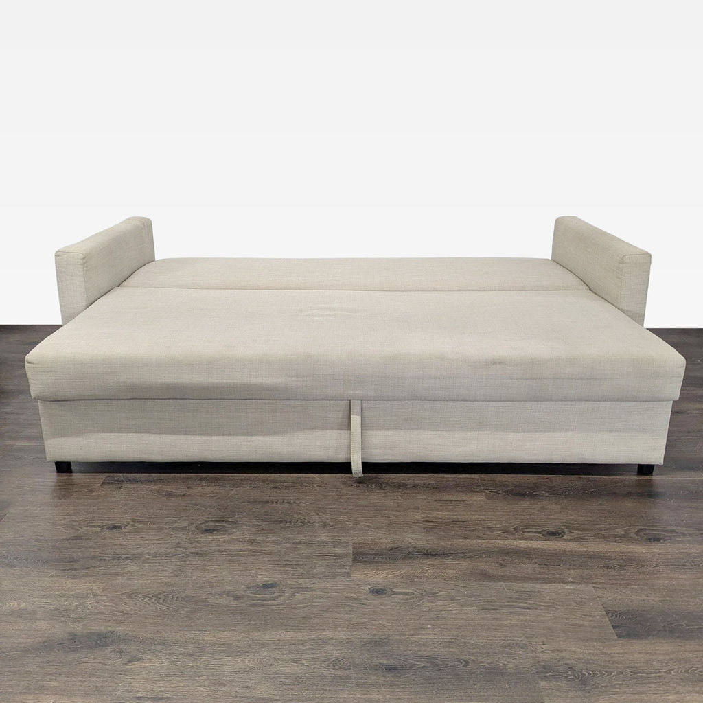Modern beige Ikea sofa that transforms into a bed, featuring soft cushions and included matching pillows.