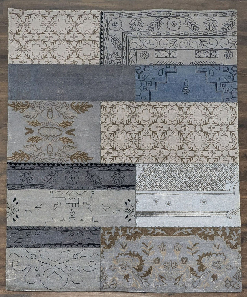 1. Overhead view of a West Elm rug with a unique patchwork design in soft blue and neutral tones.