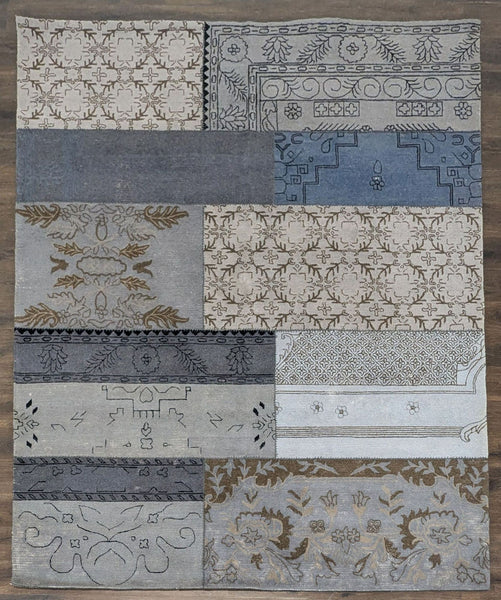 1. Overhead view of a West Elm rug with a unique patchwork design in soft blue and neutral tones.