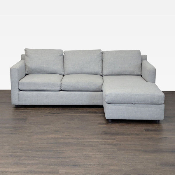 Crate and Barrel gray sectional sofa with right-facing chaise and hidden storage, seating three people.