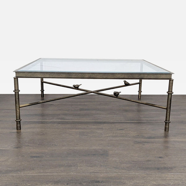 Bronze-finished iron coffee table with hammered apron, beveled glass top, and three bird-adorned stretchers.  