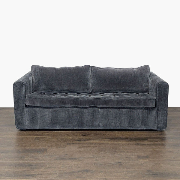 Dark gray sofa with plush cushions that converts into a pull-out bed, ideal for small spaces or guests.  