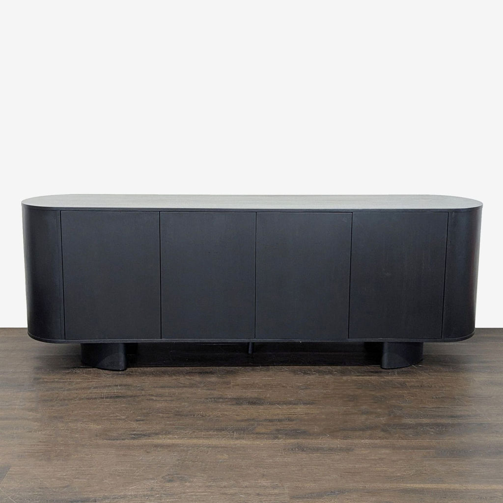 Black oak sideboard by Four Hands with four doors, adjustable shelves, and chunky legs in a Brutalist-inspired design.
