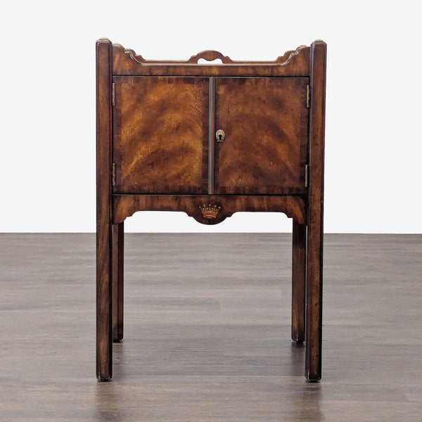 Vintage side table with carved edges, curved details, and a cabinet door for storage.  