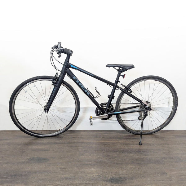1. Side view of a Trek hybrid bike with lightweight frame, kickstand, and bottle holder, ideal for commuting.