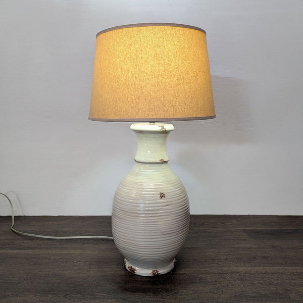 Cream ceramic table lamp with ribbed base and beige fabric shade, ideal for cozy, stylish lighting.