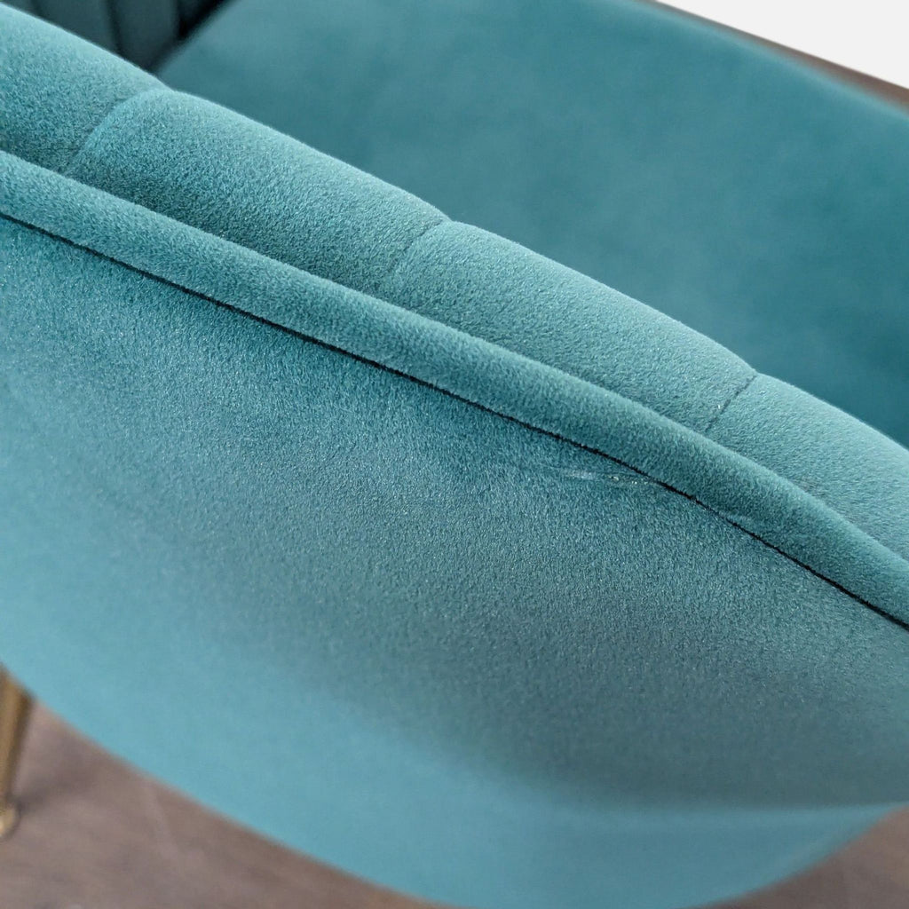 Elegant teal upholstered chair with vertical stitched design and gold metal legs, perfect for contemporary spaces.