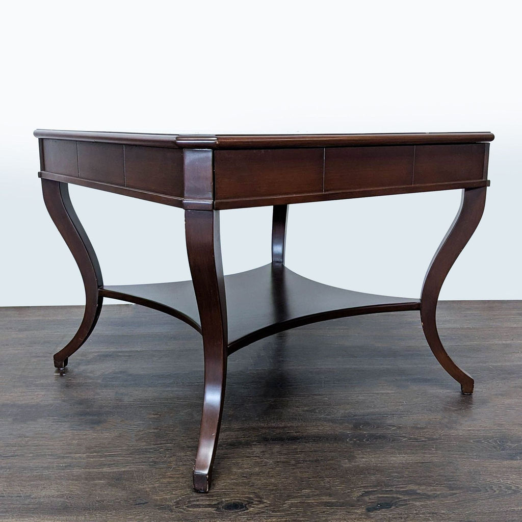 2. Angled view of a dark wood console table featuring elegant curved legs and a spacious bottom shelf.