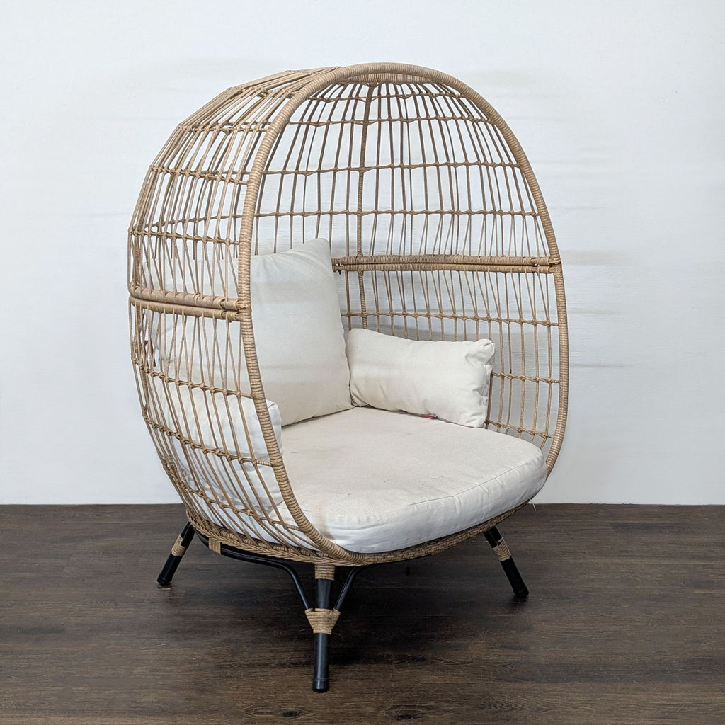 Egg-shaped rattan chair by Opal House featuring plush cream cushions, perfect for comfortable lounging.  