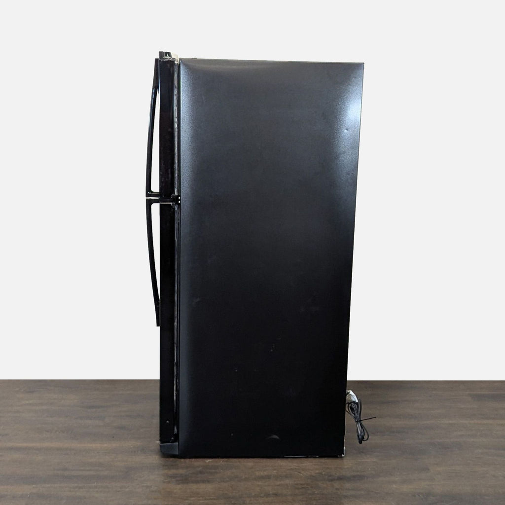 Reliable Whirlpool fridge, top-freezer style, black finish, offers generous storage; great for kitchens and garages.