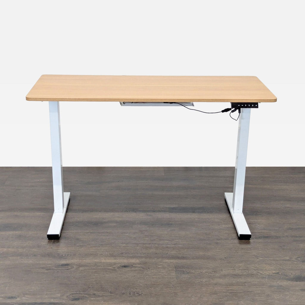Electric height-adjustable desk by The Twillery Co., with a wood-look top and white metal legs.