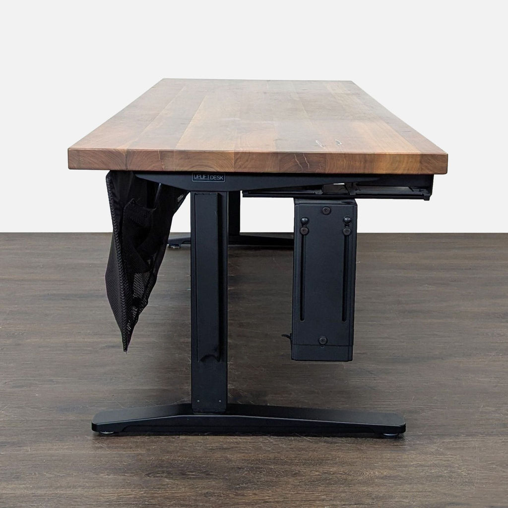Electric standing desk by Uplift, featuring solid wood desktop, dual-motor height adjustment, and tidy cable storage.