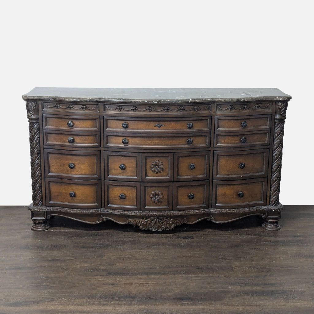 Ashley Furniture dresser with 12 drawers and a marble top, featuring classic carved details and brown finish.