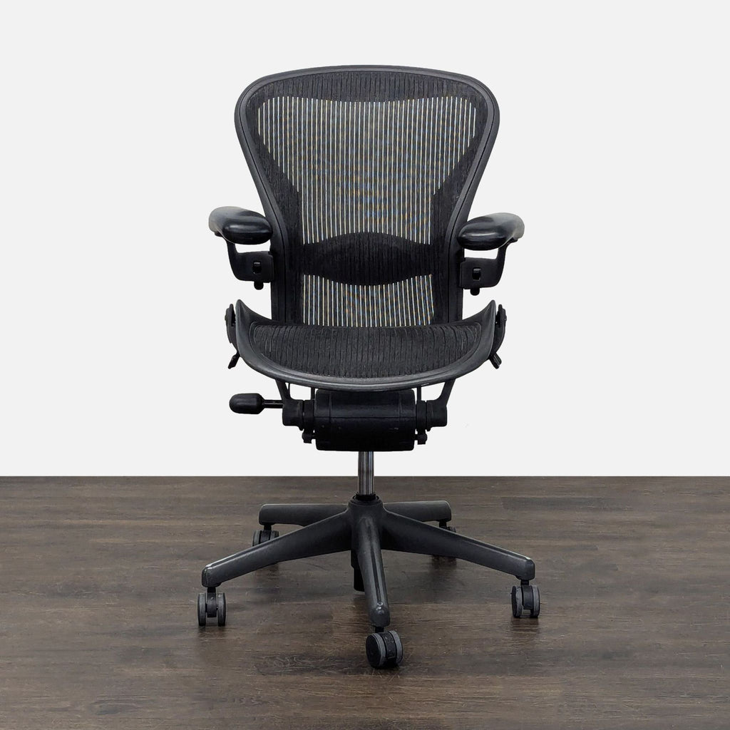 Herman Miller Aeron chair with black mesh, adjustable arms, and smooth casters for ergonomic office comfort.  