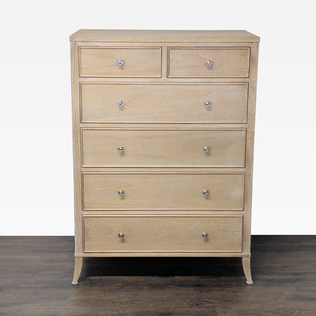 Light wood dresser by Arhaus with six drawers, metal knobs, and curved legs, offering modern bedroom storage.