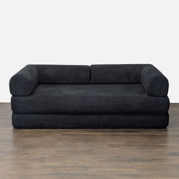 Black corduroy sleeper sofa with plush cushions, bolster arms, and a modern low-profile design.