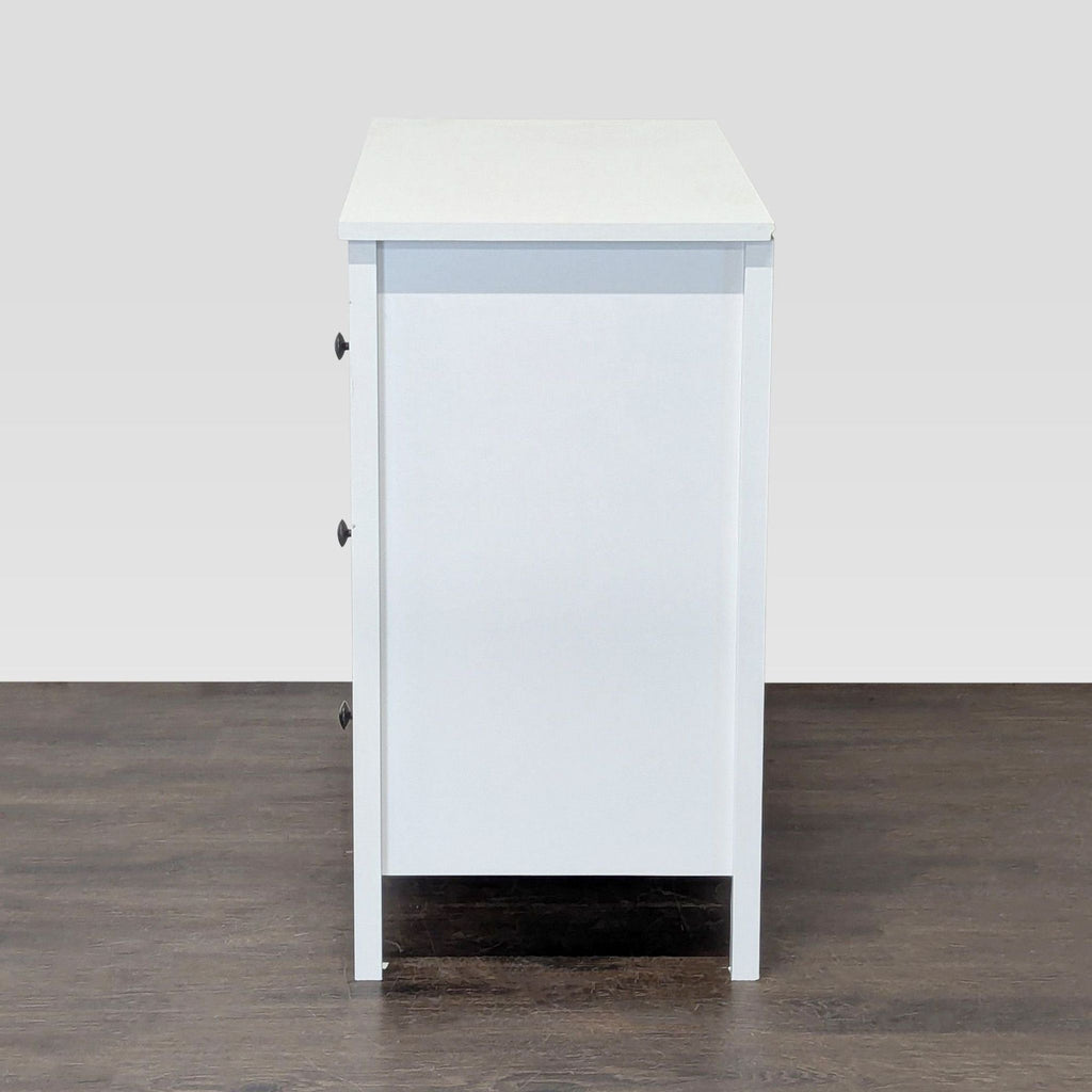 Three-drawer white dresser with simple design and black knobs, perfect for versatile storage.