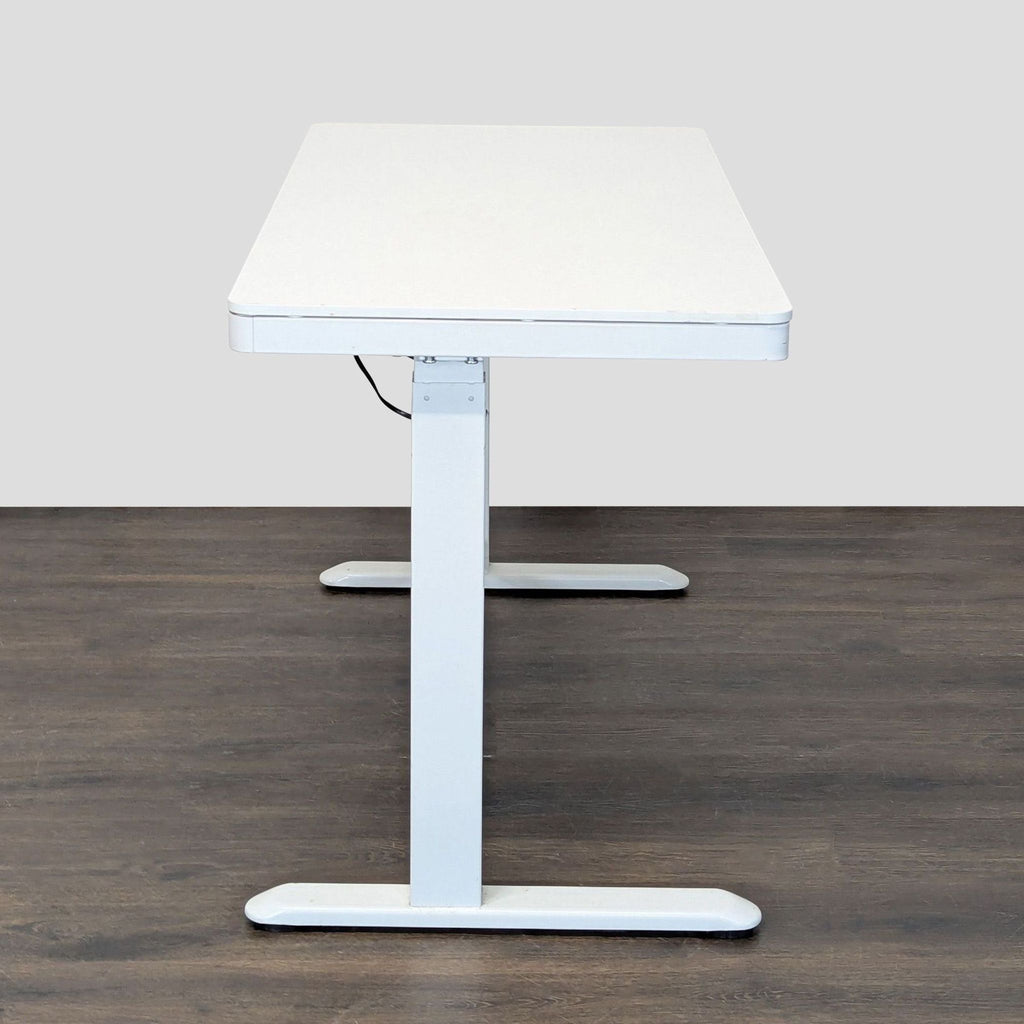 White Flexispot desk with electric lift, storage drawer, and control panel, designed for flexible sitting or standing work.