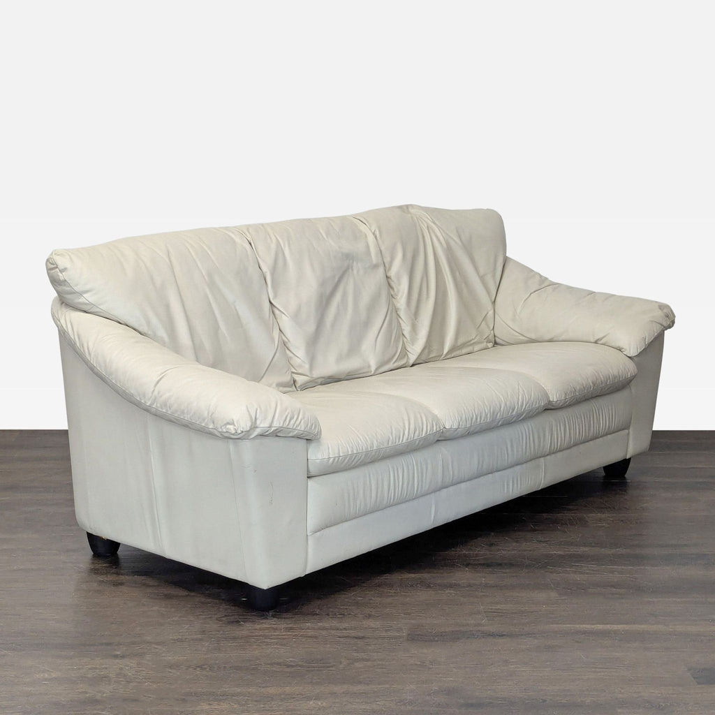 Modern cream leather 3-seater sofa with spacious armrests, ideal for living rooms; gently used condition.