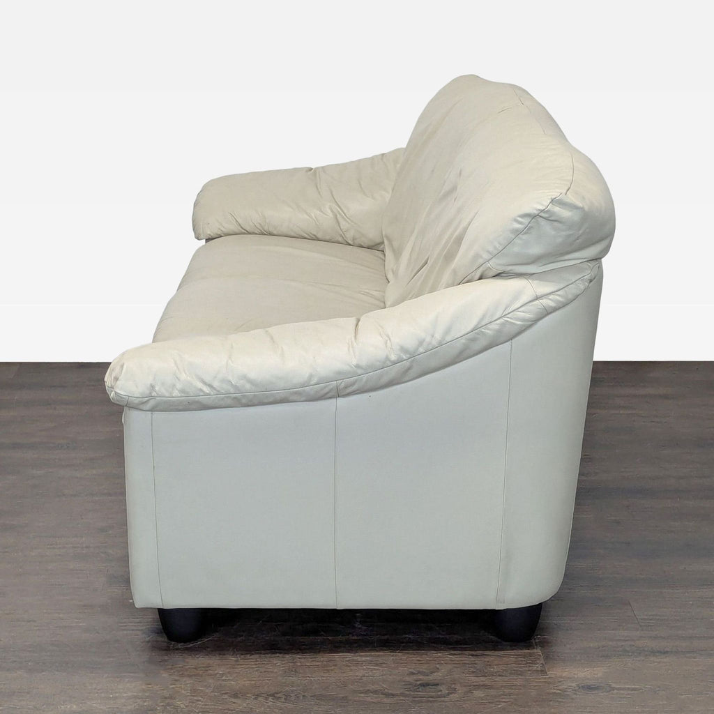 Comfortable 3-seat cream leather sofa featuring wide armrests and a sleek, modern look; well-maintained.