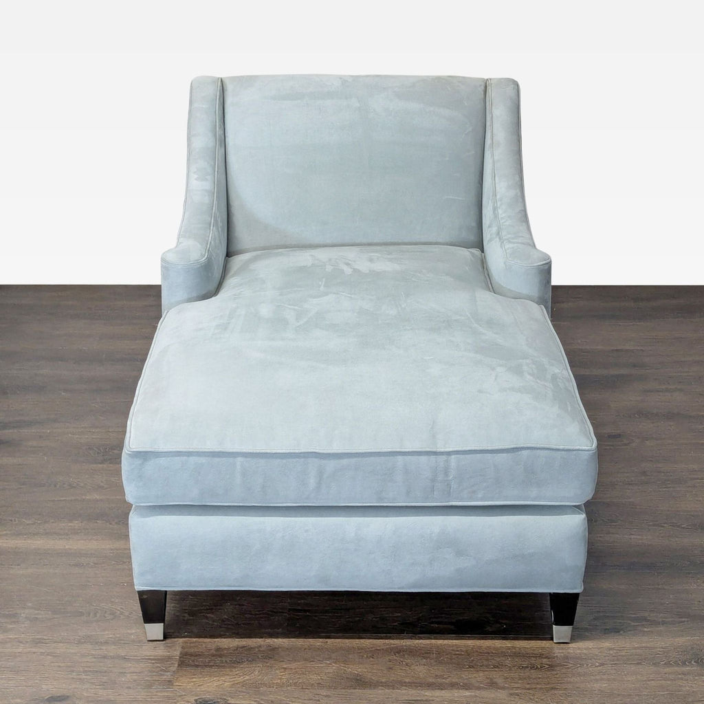 Chic chaise lounge chair in soft blue velvet upholstery, featuring a spacious seat and comfortable backrest.  