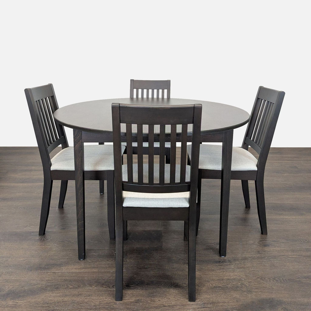 Ikea dining set with a round dark wood table and four cushioned chairs, ideal for modern dining areas.  