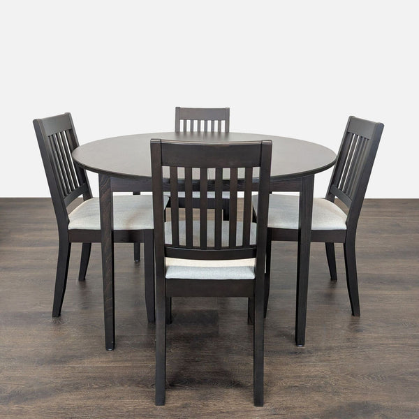 Ikea dining set with a round dark wood table and four cushioned chairs, ideal for modern dining areas.  