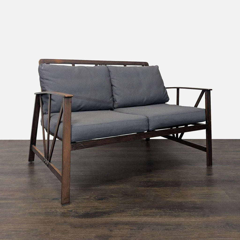 Modern living room or patio set: two-seater sofa, two chairs, and coffee table with gray cushions and dark frames.