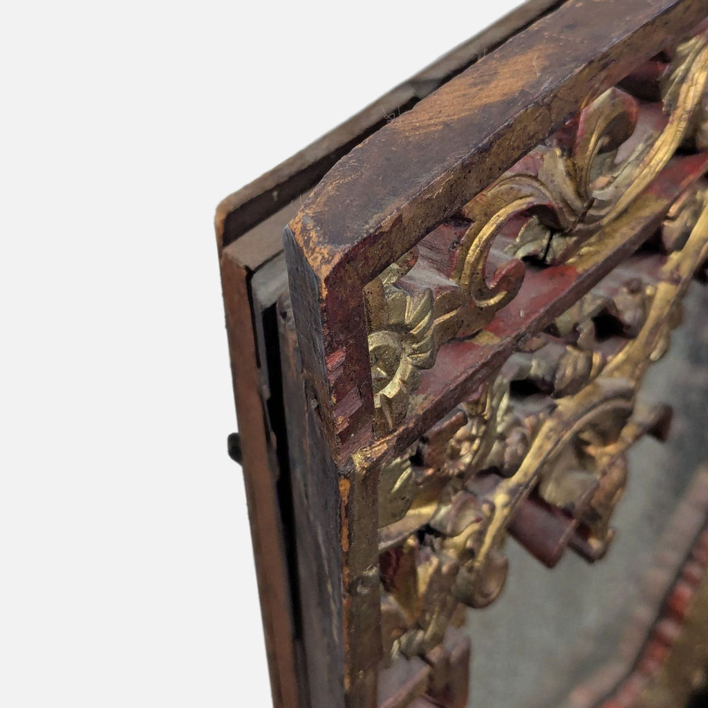 Antique mirror top with intricate gold and red lacquer carvings on wood.