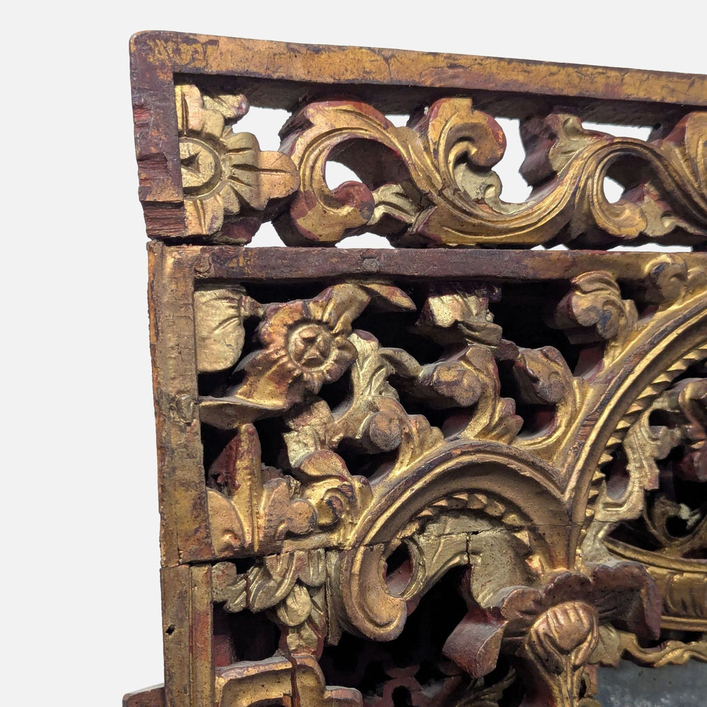 Gold-painted, red lacquered upper section of an ornate hand-carved mirror frame.