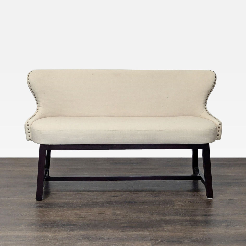 Wing-style bench with quilted back, nailhead trim, and wooden frame, ideal for seating in any room.