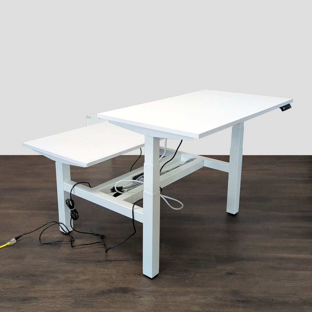 Modern Poppin adjustable desk featuring independent height controls for each white tabletop; great for collaborative spaces.  