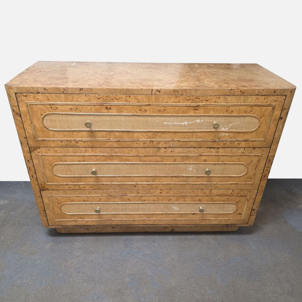 Beaumont 48" dresser by Made Goods with burl wood top, raffia drawers, gold hardware, and curved sides.