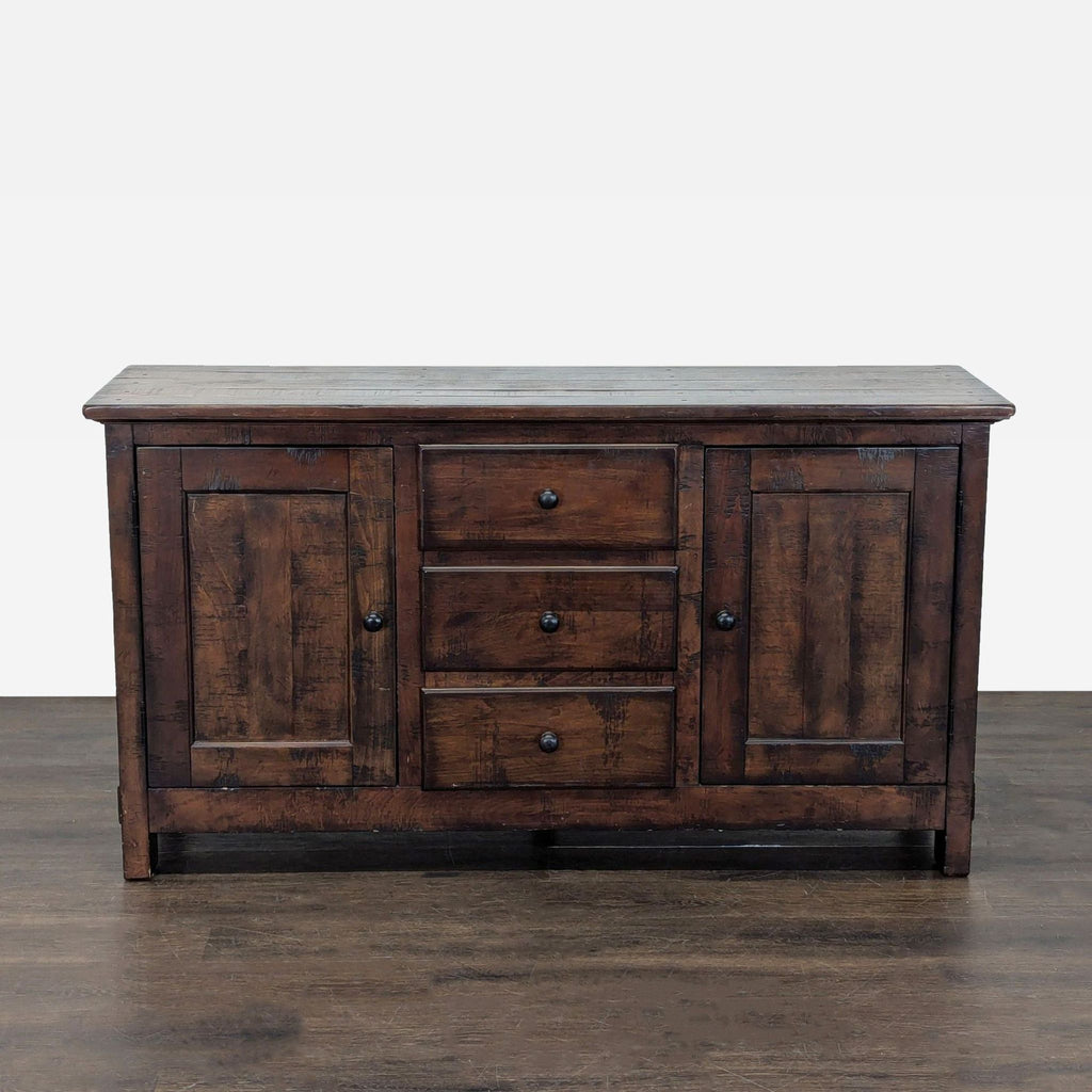 Pottery Barn sideboard with three center drawers and two shelved cabinets in rustic wood finish.