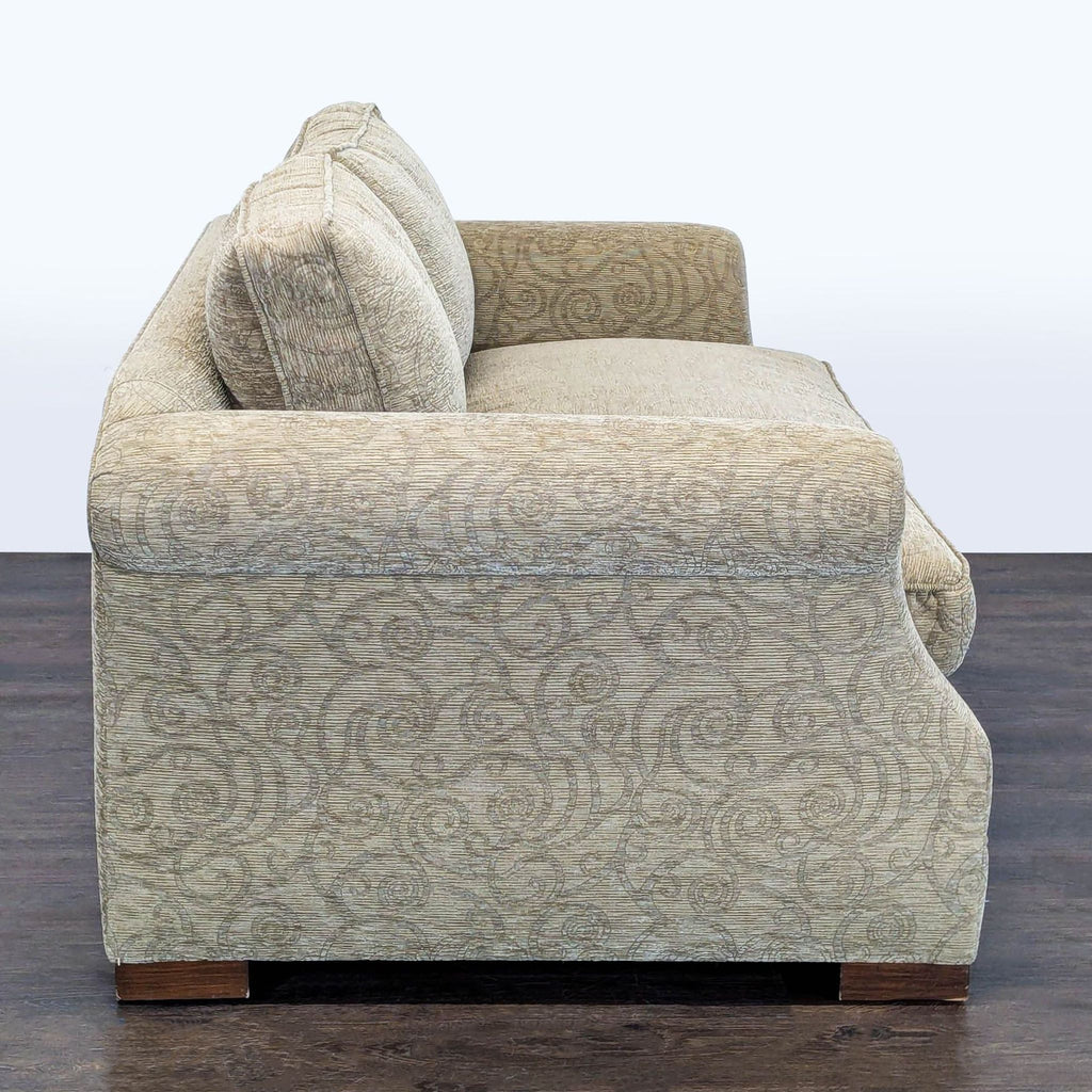 Two-seater sofa featuring rolled arms and plush cushions, suitable for small rooms or reading corners.