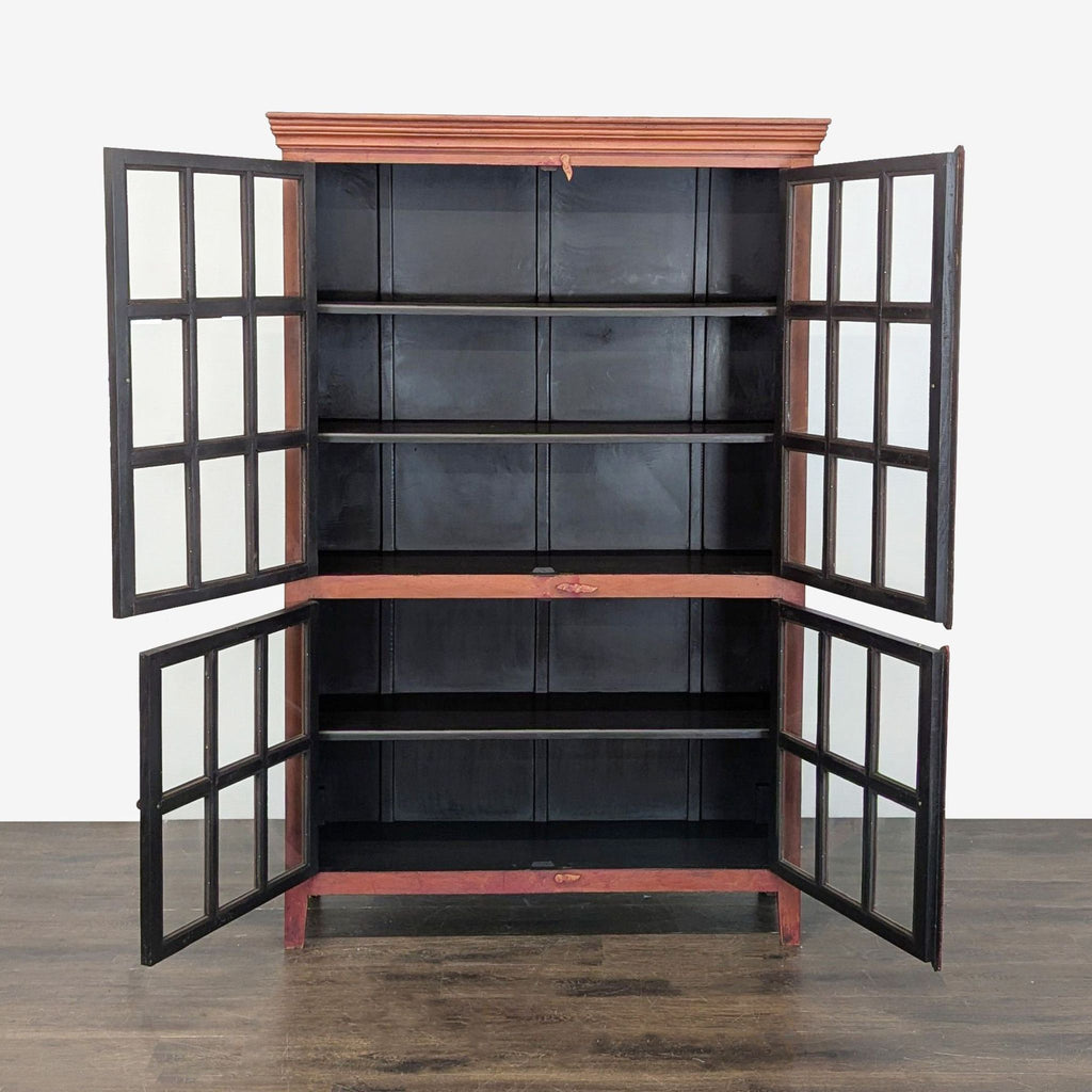 Distressed red waxed armoire by Crate & Barrel, featuring four glass doors, iron accents, and spacious shelving.