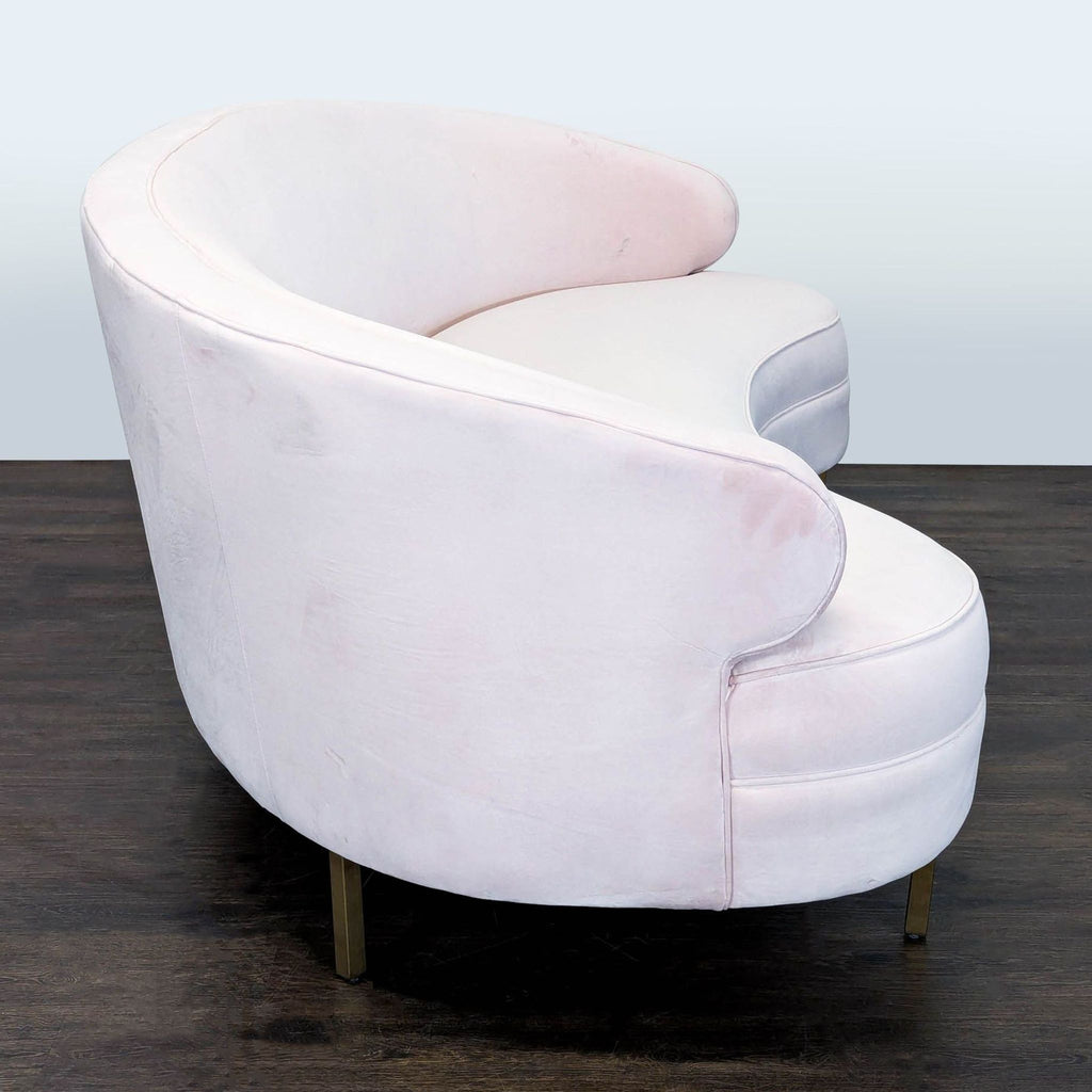 Elegant Safavieh three-seater sofa in blush pink velvet with contemporary curved form and gold accents.