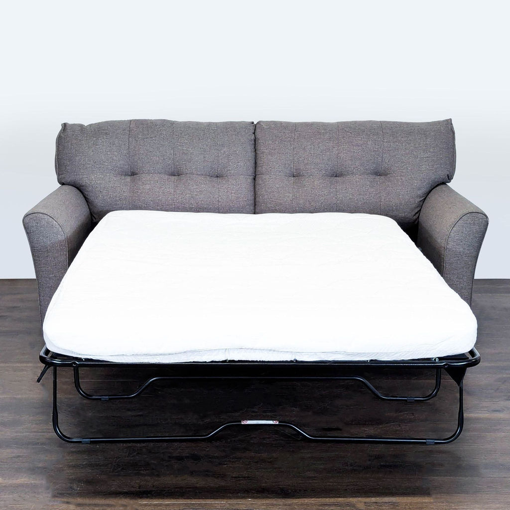 Modern gray sleeper sofa by Ashley Furniture, tufted back, supportive and comfy, ideal for small living spaces.