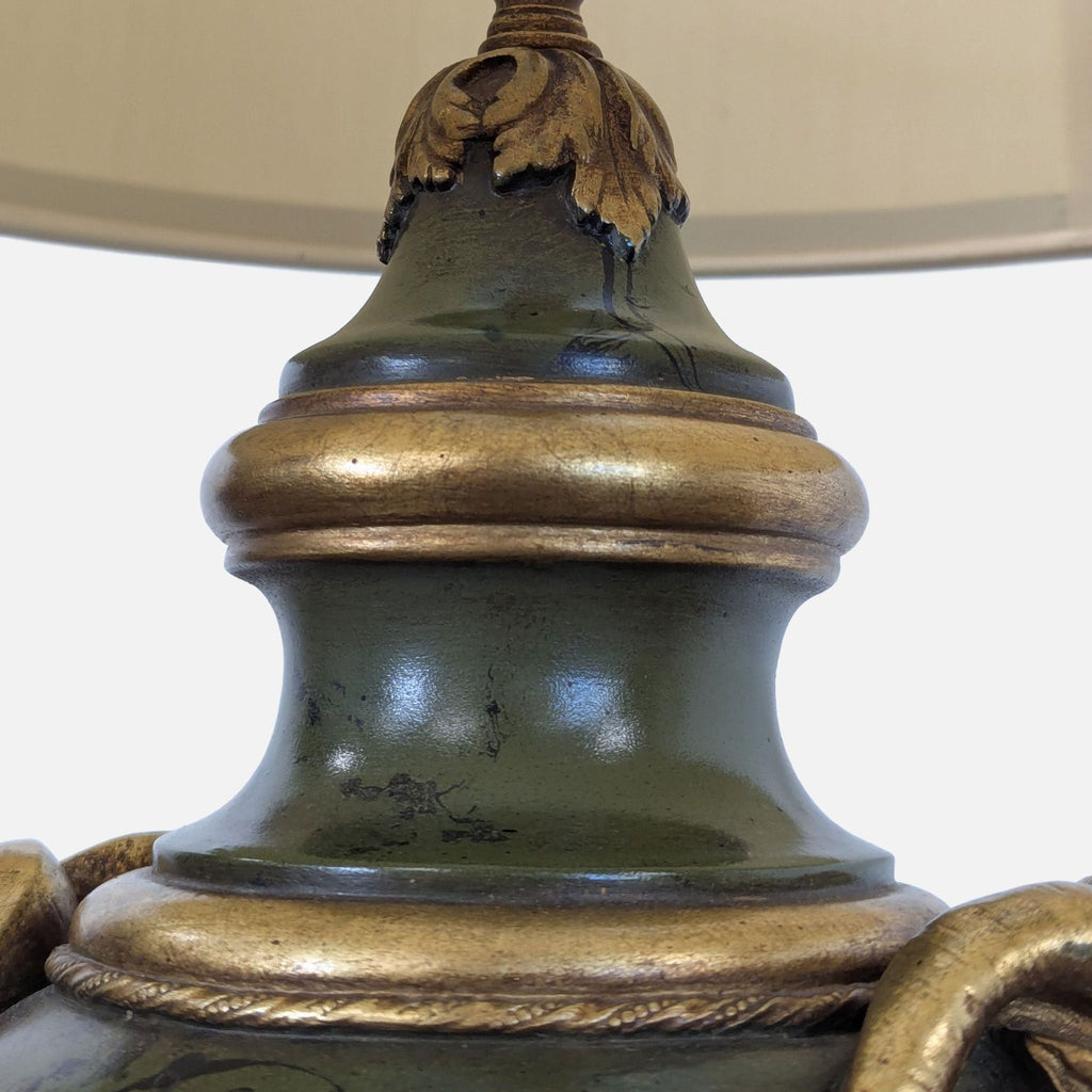 Ornate lighting piece featuring urn shape, antique gold trim, sculpted ram handles, and tall cream-trimmed drum shade.