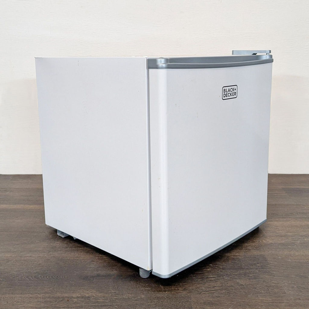 Small white Black + Decker refrigerator, fits under desks or on counters, suitable for tight spaces.  