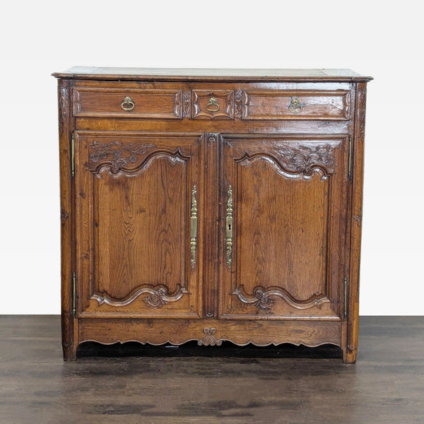 Elegant carved wood sideboard with metal hardware, three drawers, and two doors opening to spacious shelves.