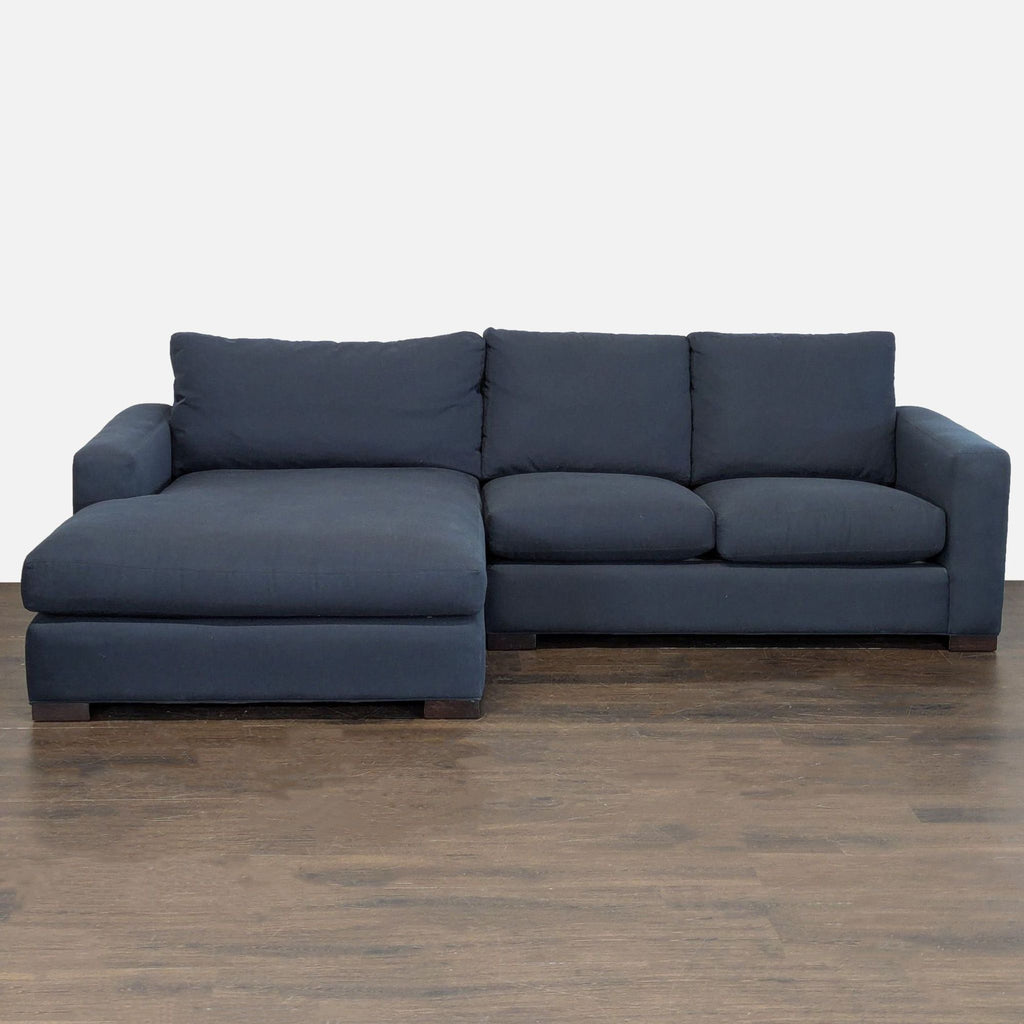 Dark blue Room and Board sectional with chaise, featuring modern design and ample seating for living rooms.